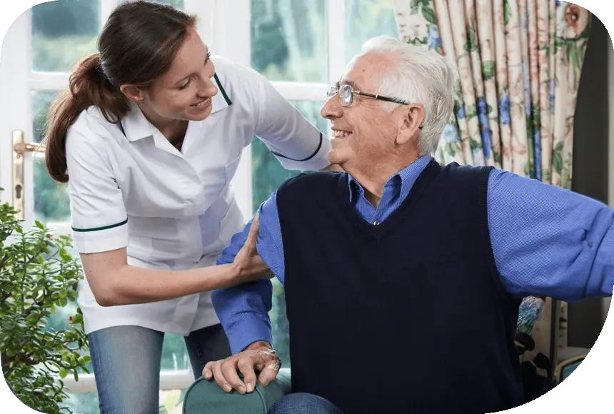 A woman helping an old man to sit on the couch