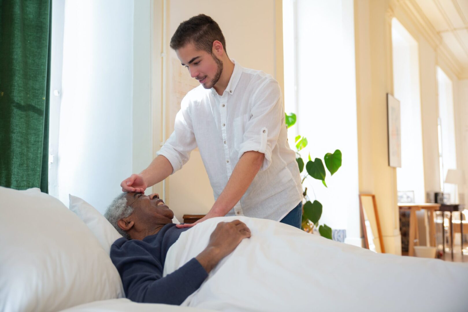 A man is helping another man in bed